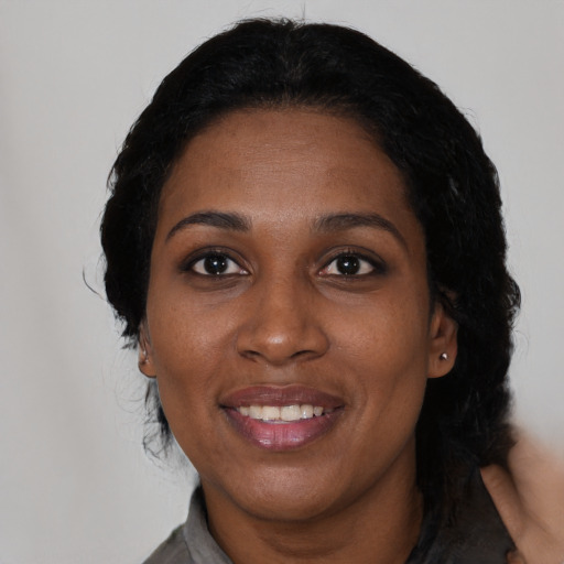Joyful black adult female with medium  black hair and brown eyes