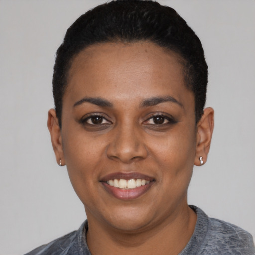 Joyful black young-adult female with short  black hair and brown eyes