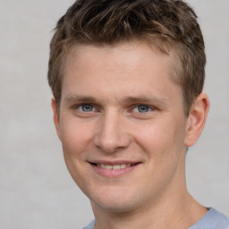 Joyful white young-adult male with short  brown hair and grey eyes