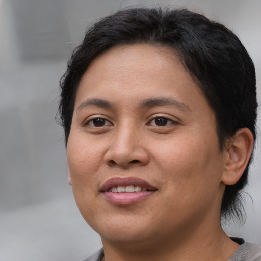 Joyful asian young-adult female with short  brown hair and brown eyes