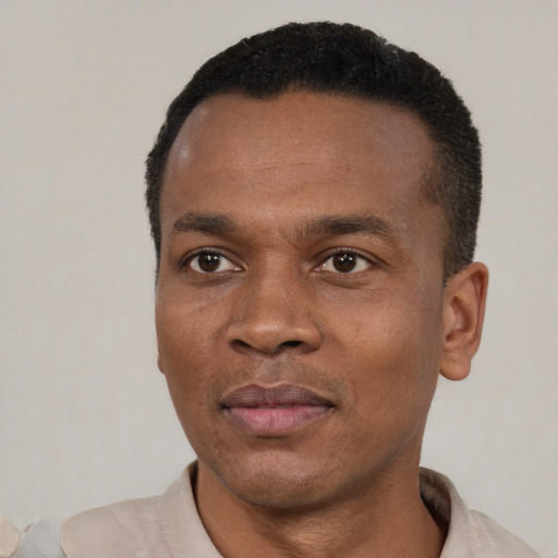 Joyful black young-adult male with short  black hair and brown eyes