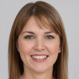 Joyful white young-adult female with long  brown hair and grey eyes