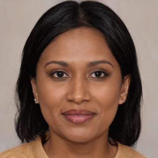 Joyful black young-adult female with medium  brown hair and brown eyes