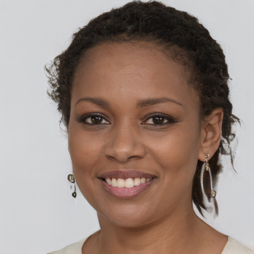 Joyful black young-adult female with long  brown hair and brown eyes