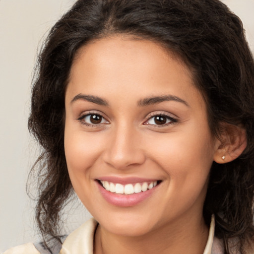 Joyful latino young-adult female with medium  brown hair and brown eyes