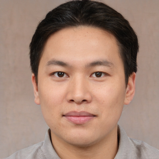 Joyful asian young-adult male with short  brown hair and brown eyes
