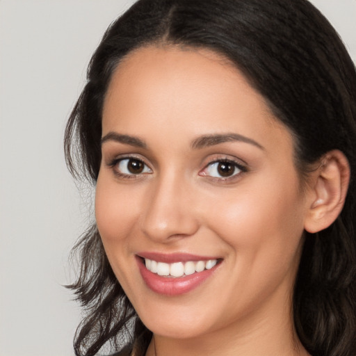 Joyful white young-adult female with long  black hair and brown eyes