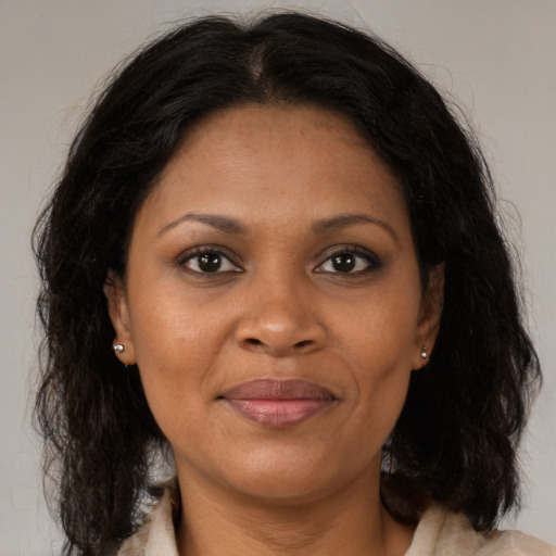 Joyful black adult female with medium  brown hair and brown eyes