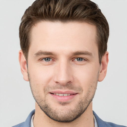 Joyful white young-adult male with short  brown hair and grey eyes