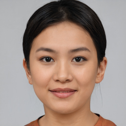 Joyful latino young-adult female with short  black hair and brown eyes
