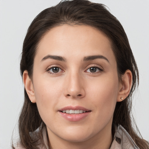 Joyful white young-adult female with long  brown hair and brown eyes