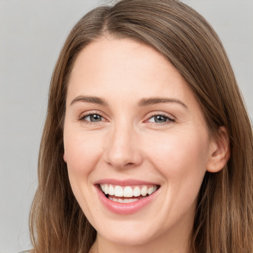 Joyful white young-adult female with long  brown hair and grey eyes