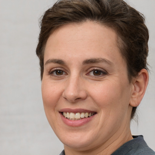 Joyful white adult female with short  brown hair and grey eyes