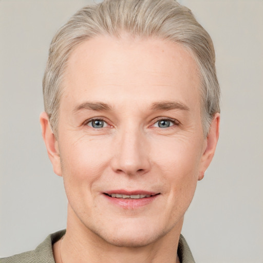 Joyful white adult male with short  blond hair and grey eyes