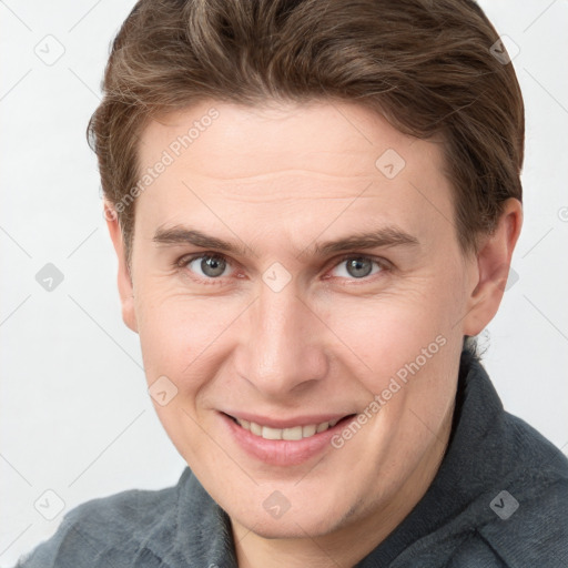 Joyful white adult male with short  brown hair and grey eyes