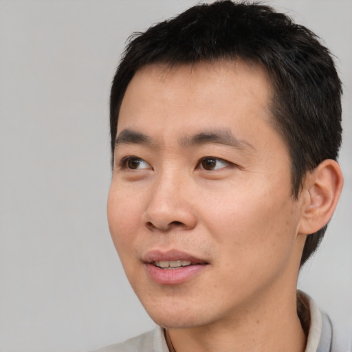 Joyful white young-adult male with short  black hair and brown eyes