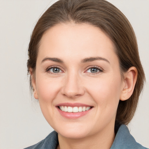 Joyful white young-adult female with medium  brown hair and grey eyes