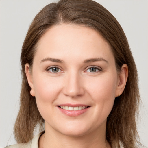 Joyful white young-adult female with long  brown hair and grey eyes