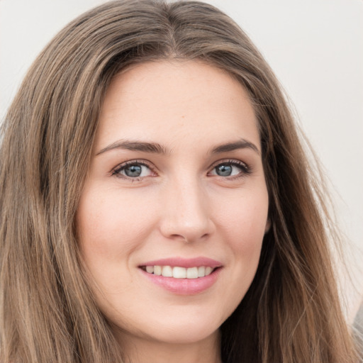 Joyful white young-adult female with long  brown hair and grey eyes