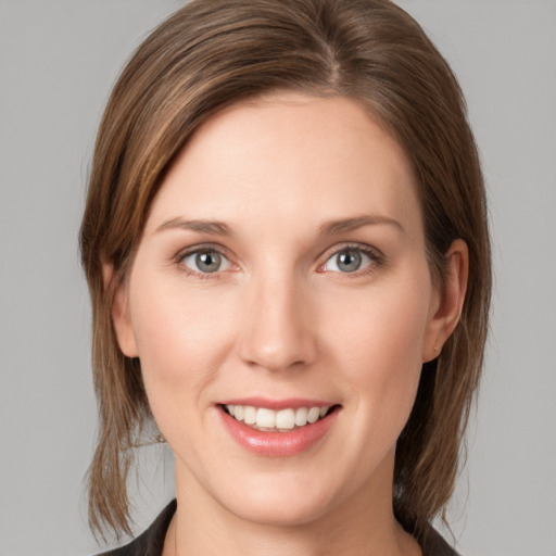 Joyful white young-adult female with medium  brown hair and grey eyes