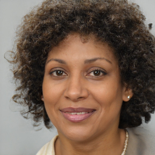 Joyful black adult female with medium  brown hair and brown eyes