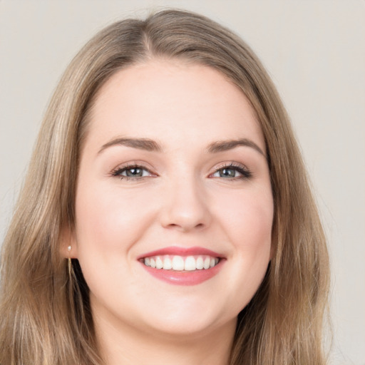 Joyful white young-adult female with long  brown hair and grey eyes