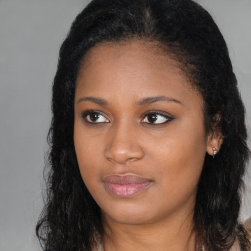 Joyful black young-adult female with long  brown hair and brown eyes
