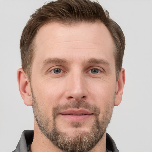 Joyful white adult male with short  brown hair and grey eyes