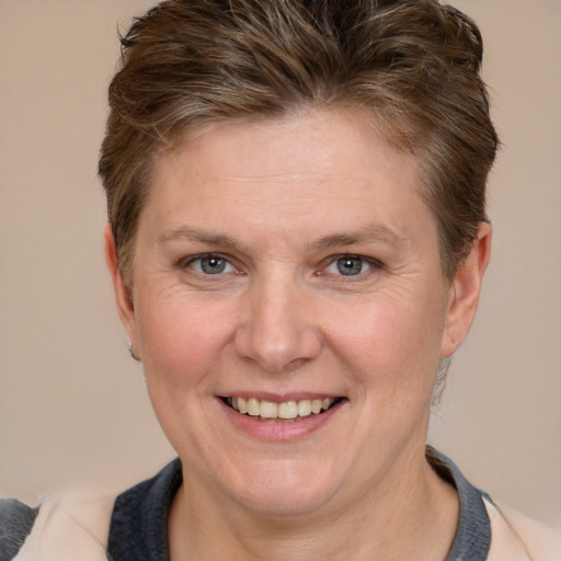 Joyful white adult female with short  brown hair and grey eyes