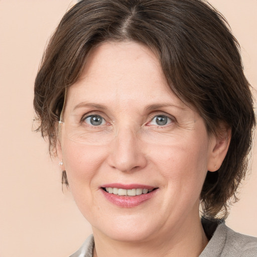 Joyful white adult female with medium  brown hair and grey eyes