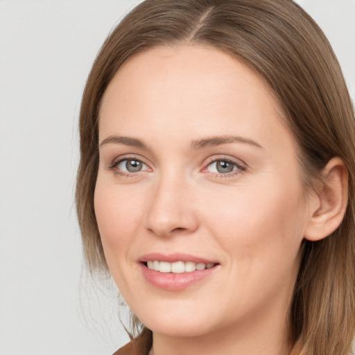 Joyful white young-adult female with long  brown hair and grey eyes