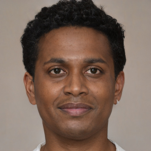 Joyful black young-adult male with short  brown hair and brown eyes