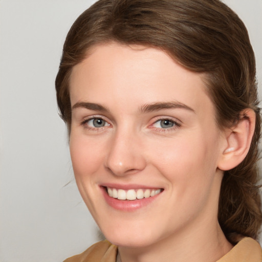 Joyful white young-adult female with medium  brown hair and grey eyes