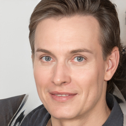 Joyful white adult male with medium  brown hair and grey eyes