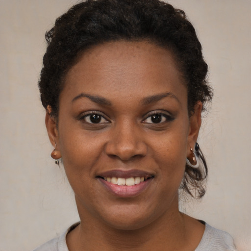 Joyful black young-adult female with short  brown hair and brown eyes