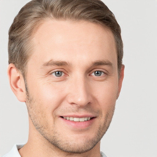 Joyful white young-adult male with short  brown hair and grey eyes