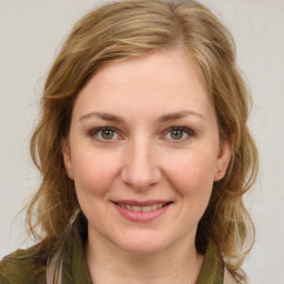 Joyful white young-adult female with medium  brown hair and green eyes