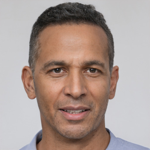 Joyful latino adult male with short  black hair and brown eyes