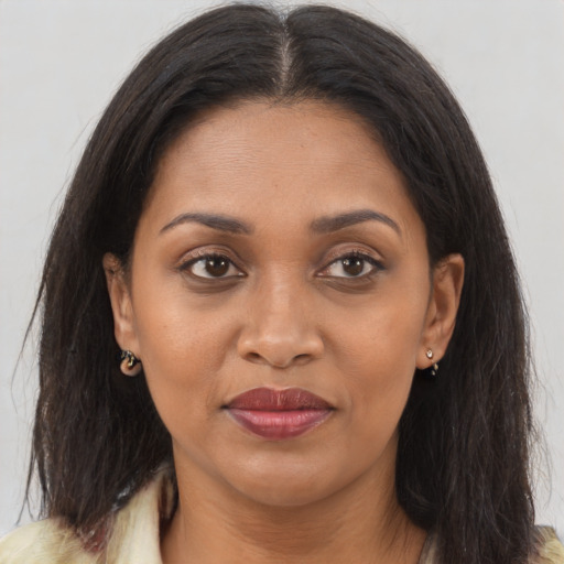 Joyful black young-adult female with long  brown hair and brown eyes
