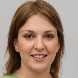 Joyful white young-adult female with medium  brown hair and green eyes