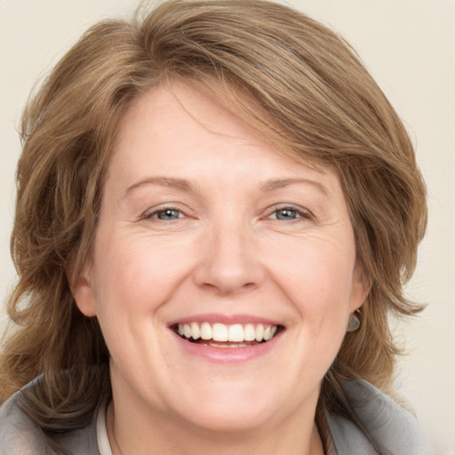 Joyful white adult female with medium  brown hair and blue eyes