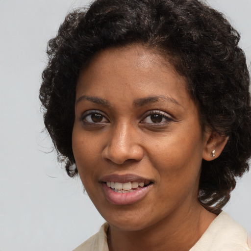 Joyful black adult female with long  brown hair and brown eyes