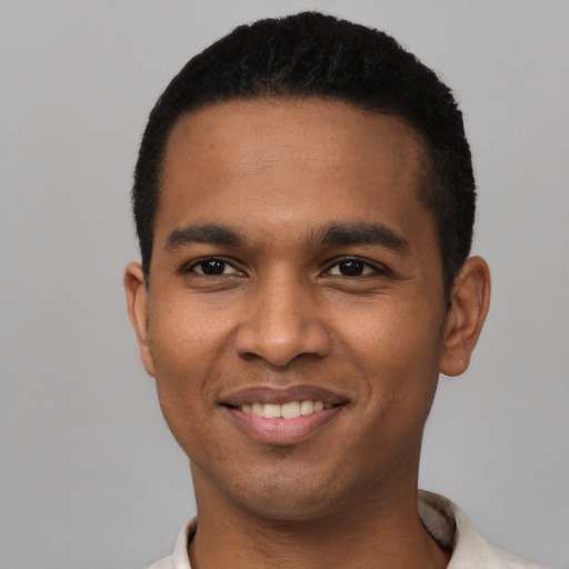 Joyful black young-adult male with short  black hair and brown eyes