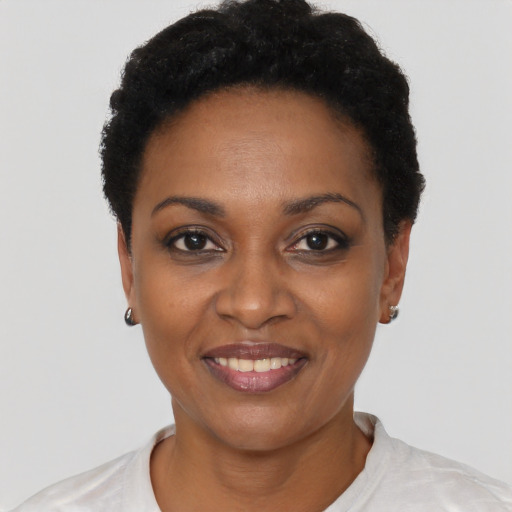 Joyful black young-adult female with short  black hair and brown eyes