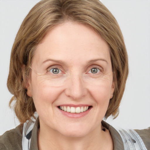 Joyful white adult female with medium  brown hair and blue eyes