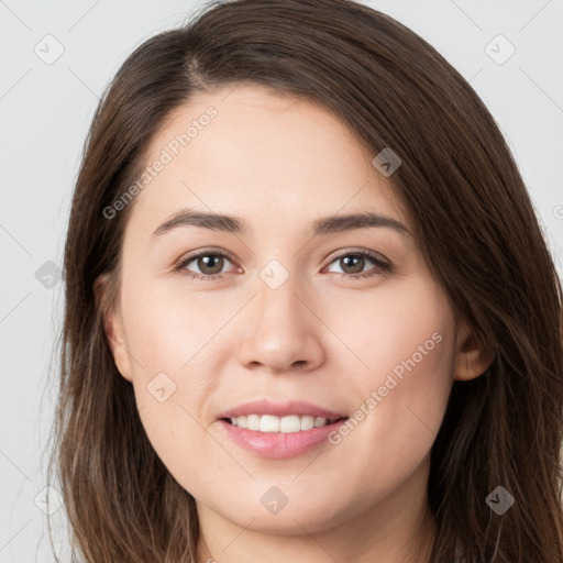 Joyful white young-adult female with long  brown hair and brown eyes