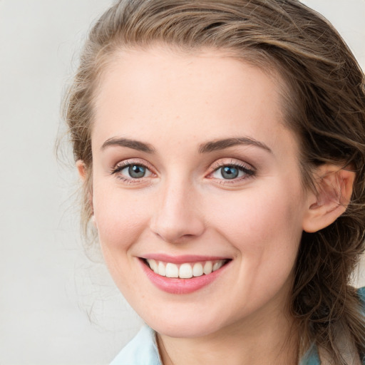 Joyful white young-adult female with medium  brown hair and blue eyes