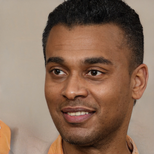 Joyful black young-adult male with short  black hair and brown eyes