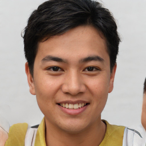 Joyful asian young-adult male with short  brown hair and brown eyes
