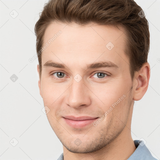 Joyful white young-adult male with short  brown hair and grey eyes